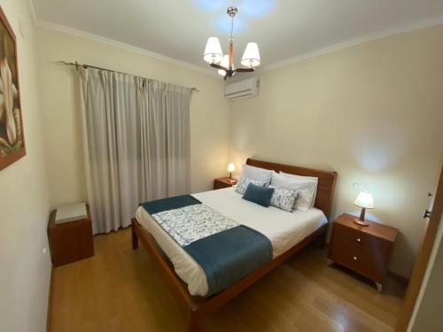 een slaapkamer met een bed met 2 nachtkastjes en 2 lampen bij Casa de Pichoses in Geres