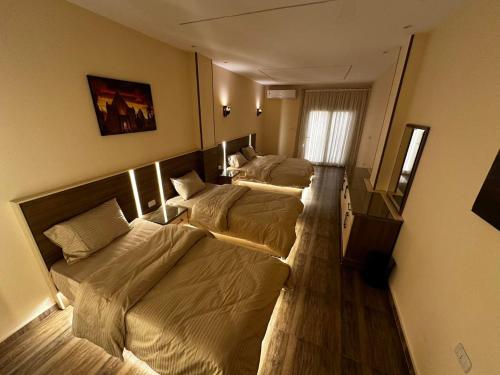 カイロにあるNarmer Pyramids Viewのベッド3台が並ぶ客室です。