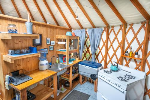 a kitchen with a stove and a sink in a tent at Orca Island Cabins in Seward