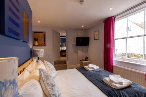 a bedroom with a bed and a tv and a window at The Old Vicarage Hotel & Restaurant in Bridgwater