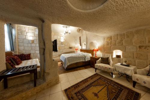 a large room with a bedroom with a bed and a couch at Cappadocia Cave Suites Adult Only in Goreme