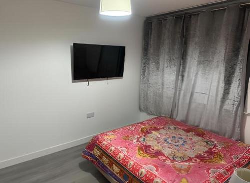 a bedroom with a bed and a flat screen tv at OYO Stay Inn Elmbank Terrace in Aberdeen