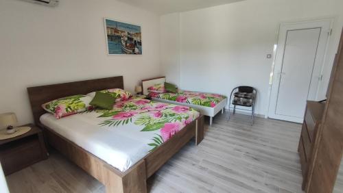 a bedroom with two beds and a chair at Viktor rooms and apartments 2 in Rovinj