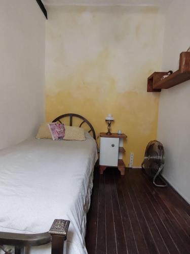 Habitación con 2 camas y mesa con ventilador. en La Risa de la Medusa en Buenos Aires