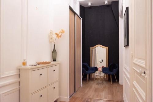- un couloir avec un miroir et des chaises bleues dans la chambre dans l'établissement Apartment Arc de Triomphe Champs Elysées, à Paris