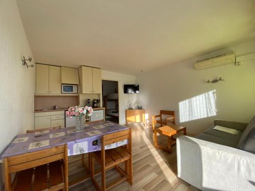 une cuisine et un salon avec une table et un canapé dans l'établissement Sol-y-Days Cigales de mer, studios bien équipés et climatisés, en centre-ville à 150m de la plage, au Grau-du-Roi