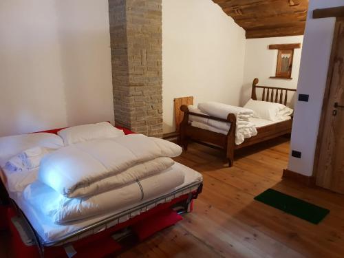 ein Zimmer mit einem Bett und ein paar Betten in der Unterkunft Villaggio Borgomaira La Ginestra 