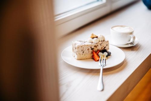 a piece of cake on a plate with a fork at Seehotel am Kaiserstrand in Lochau