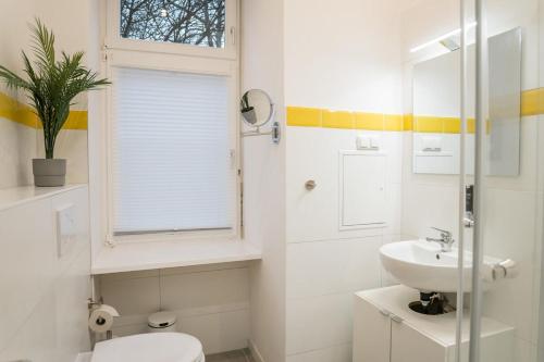a bathroom with a sink and a toilet and a window at Nahe Boxhagener Platz für 4 Personen in Berlin