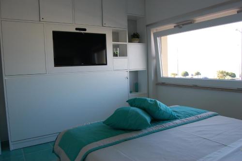 a bedroom with a bed with a flat screen tv at La Madegra Seasuite in Salerno