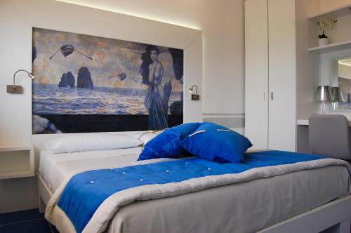 a bedroom with a bed with blue pillows on it at La Madegra Seasuite in Salerno