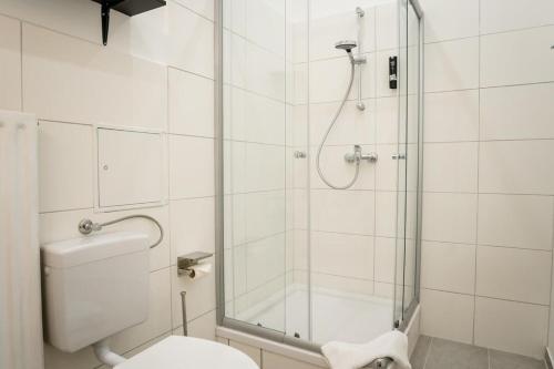un bagno con doccia in vetro e WC di Spacious 3BR plus AC Self Check-in Street Parking a Berlino
