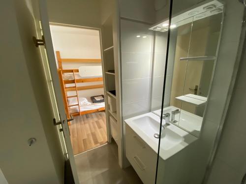 un bagno con lavandino e doccia in vetro di Sol-y-Days Cigales de mer, studios bien équipés et climatisés, en centre-ville à 150m de la plage a Le Grau-du-Roi