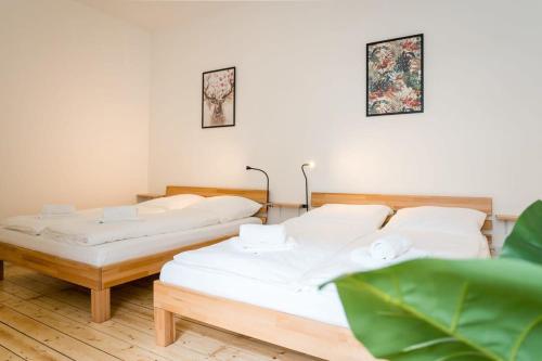 due letti in una stanza con pareti bianche di Spacious 3BR plus AC Self Check-in Street Parking a Berlino