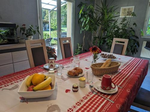 - une table avec une assiette de fruits et de pain dans l'établissement Séjour paisible à la campagne près d'Épinal - Chambre familiale idéale pour amoureux de la nature - FR-1-589-612, à Chantraine