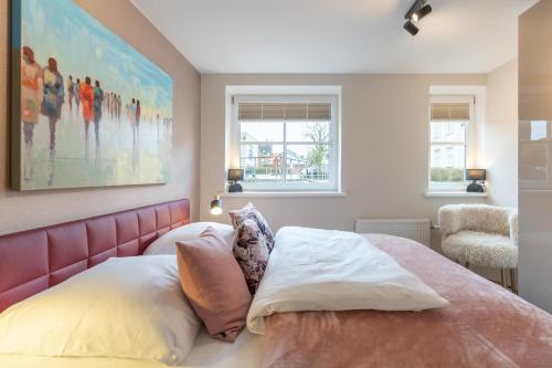 フーズムにあるFerienwohnung Hafen-Zeit direkt am Husumer Hafenのベッドルーム1室(ピンクのヘッドボードと枕付きのベッド1台付)