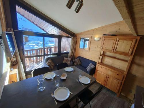 une salle à manger avec une table et un canapé dans l'établissement Appartement cosy rénové à Val Thorens - 4 personnes, balcon, proche pistes et commerces - FR-1-637-79, à Val Thorens