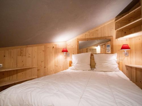 - une chambre avec un grand lit blanc et des murs en bois dans l'établissement Appartement cosy rénové à Val Thorens - 4 personnes, balcon, proche pistes et commerces - FR-1-637-79, à Val Thorens