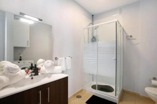 a bathroom with a glass shower and a sink at Atlantic Blue Dream Caletillas in Araya
