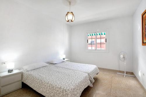 - une chambre blanche avec un lit et une fenêtre dans l'établissement Atlantic Blue Dream Caletillas, à Araya