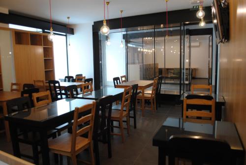 a dining room with tables and chairs and windows at Moderna in Coimbra