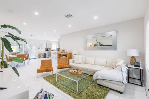 a living room with a couch and a table at Olas Villa by Rove Travel - Home with Heated Pool in Fort Lauderdale