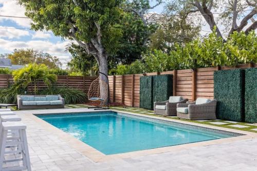 a swimming pool in a backyard with a fence at Olas Villa by Rove Travel - Home with Heated Pool in Fort Lauderdale