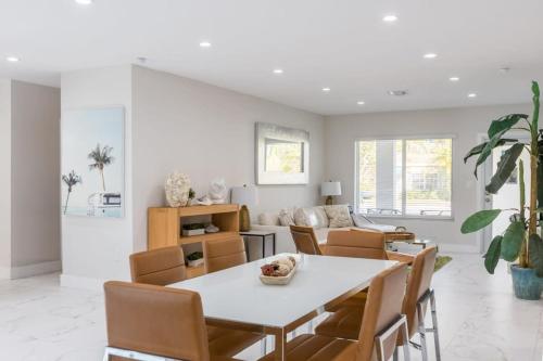 a dining room with a white table and chairs at Olas Villa by Rove Travel - Home with Heated Pool in Fort Lauderdale