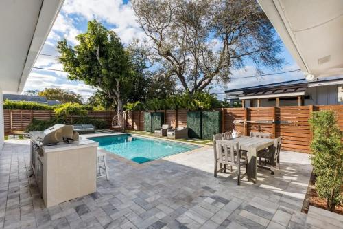 a backyard with a pool and a table and chairs at Olas Villa by Rove Travel - Home with Heated Pool in Fort Lauderdale