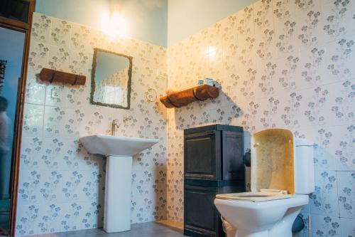 a bathroom with a toilet and a sink at Shell Resort in Arugam Bay