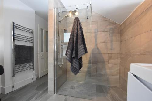 a bathroom with a shower with a glass door at Tilling View with private parking in Rye