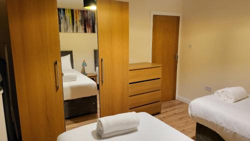 a small bedroom with two beds and a closet at Garland Modern Spacious Apartment With Garden in Edgware