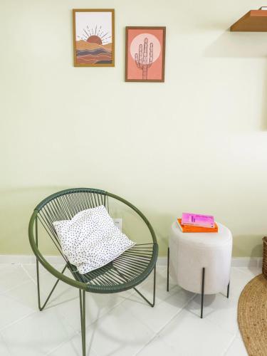 a green chair and a stool in a room at Casas Wave in Maceió