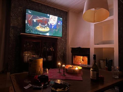 ein Wohnzimmer mit einem Tisch, einem TV und einem Kamin in der Unterkunft Stunning6B2B views,jacuzzi,sauna 