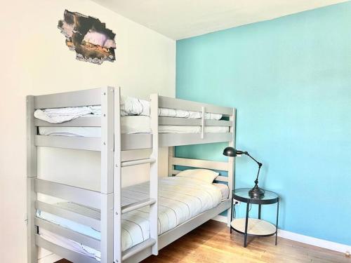 a bedroom with two bunk beds and a lamp at La baillargeoise - Superbe maison à 7 min du parc in Saint-Georges-lès-Baillargeaux