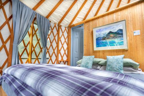 1 dormitorio con 1 cama en una yurta en Orca Island Cabins, en Seward