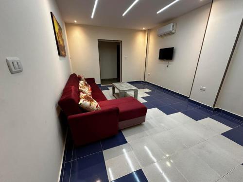 a living room with a red couch and a tv at Narmer Pyramids View in Cairo