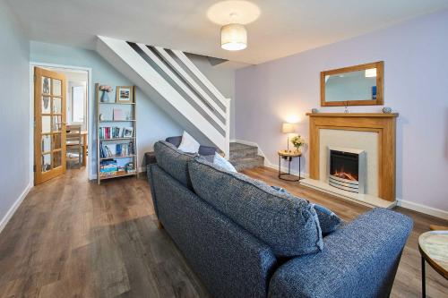 a living room with a blue couch and a fireplace at Host & Stay - Station View in Saltburn-by-the-Sea
