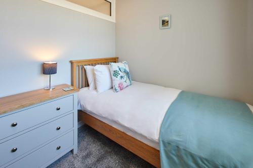 a bedroom with a bed and a dresser with a lamp at Host & Stay - Station View in Saltburn-by-the-Sea