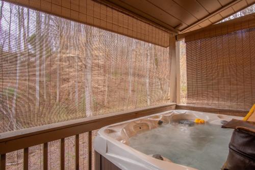 a jacuzzi tub in a screened in porch at Cozy Cabin Retreat: Tiny Trotter in Bryson City