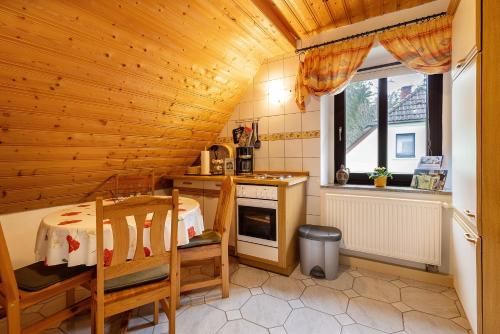 a kitchen with a wooden ceiling with a table and a stove at Buchhaus Vier - Dachgeschoss in Kirchenlamitz