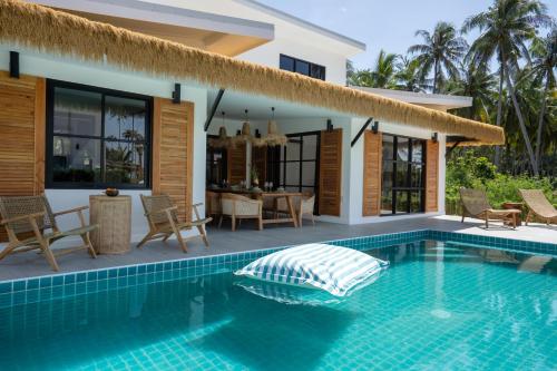 a villa with a swimming pool in front of a house at Luxury Beachhouse Manao Villas in Ko Lanta