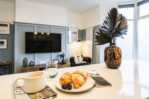 a table with a plate of pastries and a cup of coffee at Newport's heart: Steps from shops & local charm! in Newport