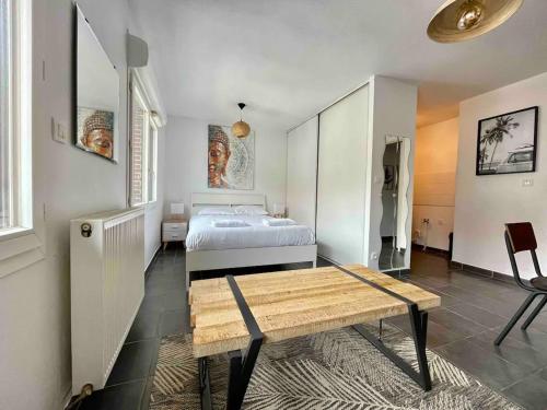 une chambre avec un lit et une table en bois dans l'établissement Taquin by Yumē, à Toulouse