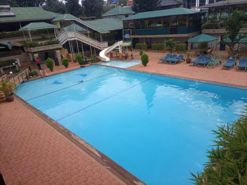 Elle offre une vue sur une grande piscine bleue dotée d'un toboggan. dans l'établissement Deep Sea Resort, à Kitale
