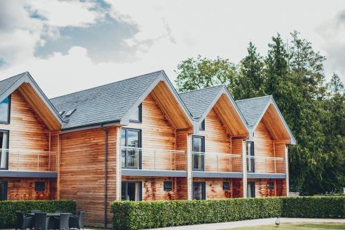 une rangée de maisons en bois dans l'établissement Azalea Northbrook Park Chalet, à Farnham