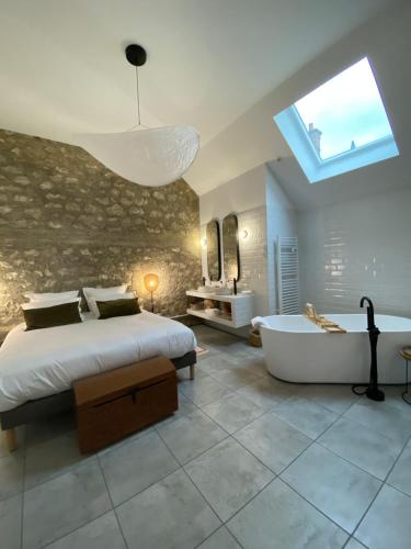 a bedroom with a large bed and a bath tub at La Suite Arbane SPA & sauna - Avarum in Ay