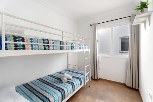 a bedroom with two bunk beds and a window at Atico San Jose in La Victoria de Acentejo