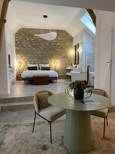 a bedroom with a bed and a table in a room at La Suite Arbane SPA & sauna - Avarum in Ay