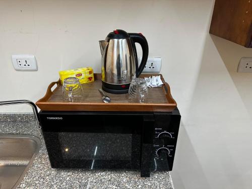 a tea kettle sitting on top of a microwave at Narmer Pyramids View in Cairo